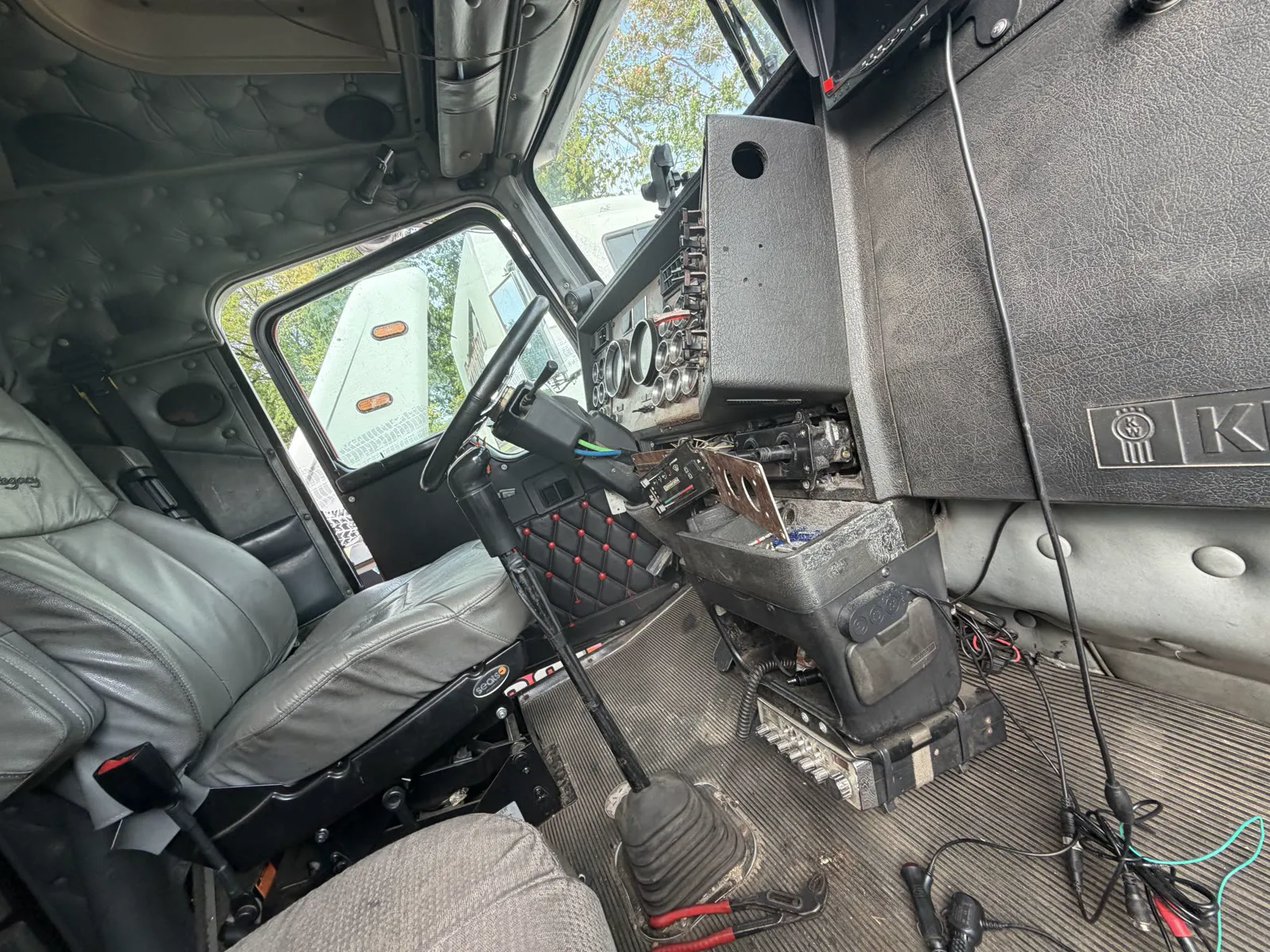 Technician working dashboard diagnostics inside a commercial truck