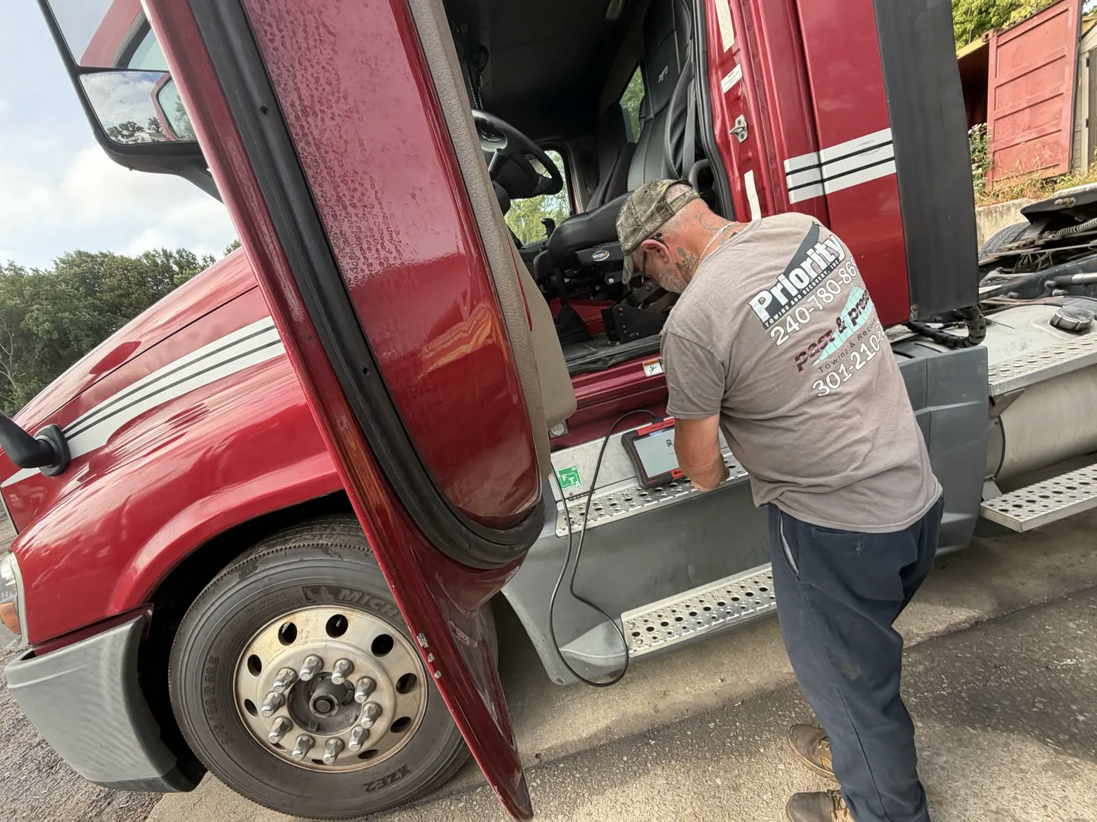 Diesel technician with diagnostic tablet at the truck cab