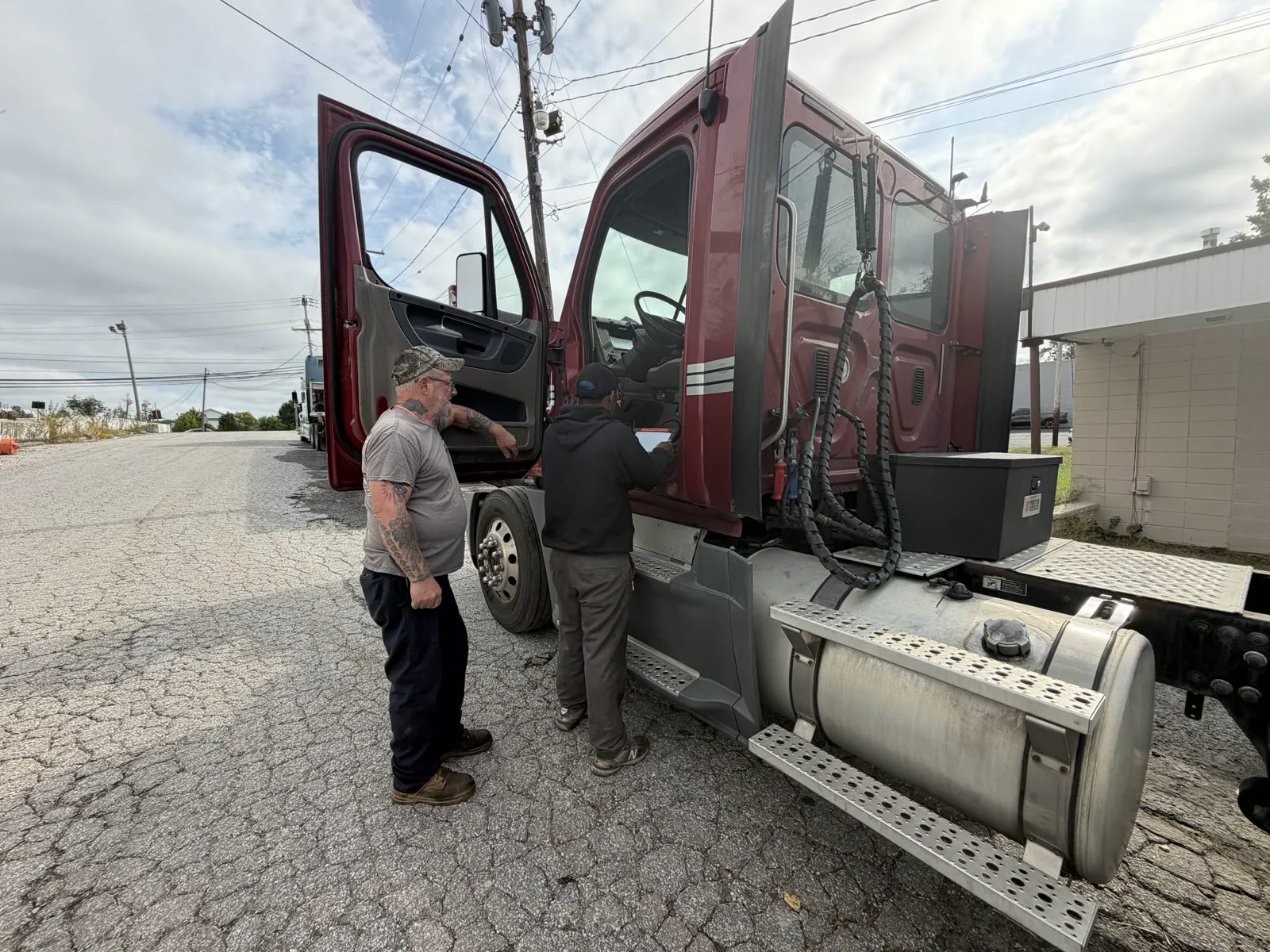 Two Priority diesel technicians diagnosing a commercial truck roadside