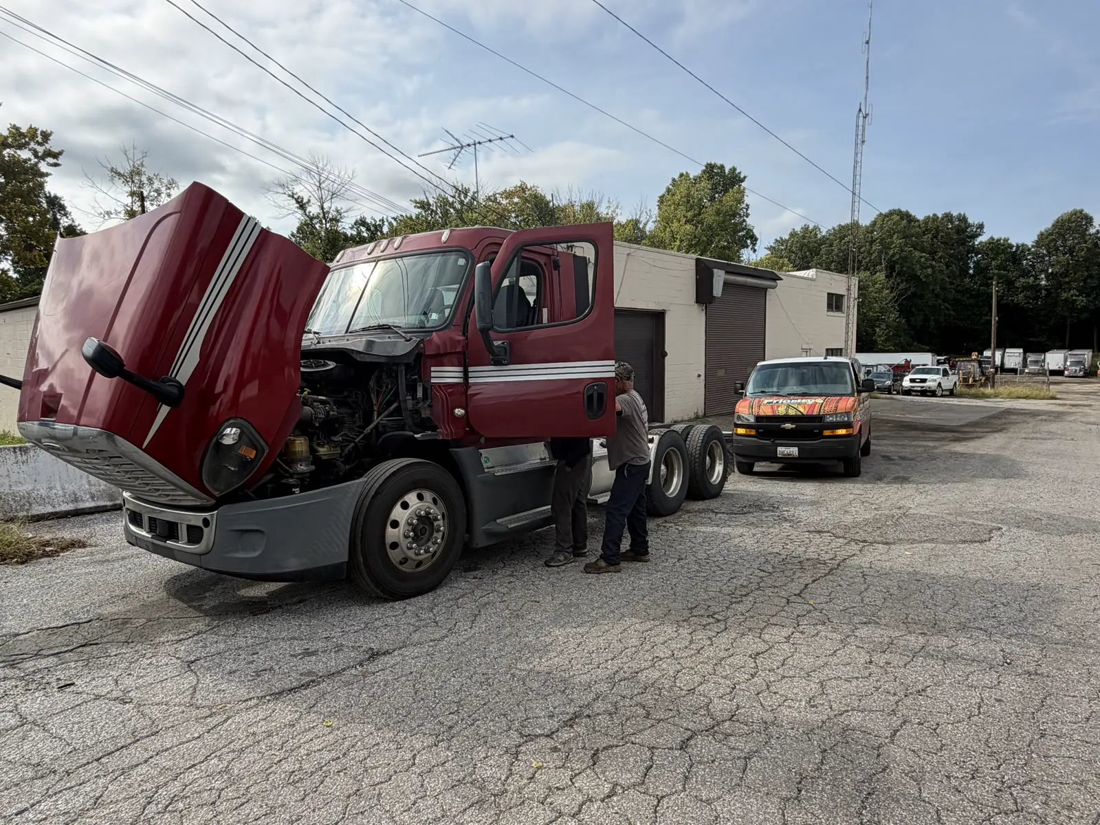 Priority mobile repair van behind a semi with hood open